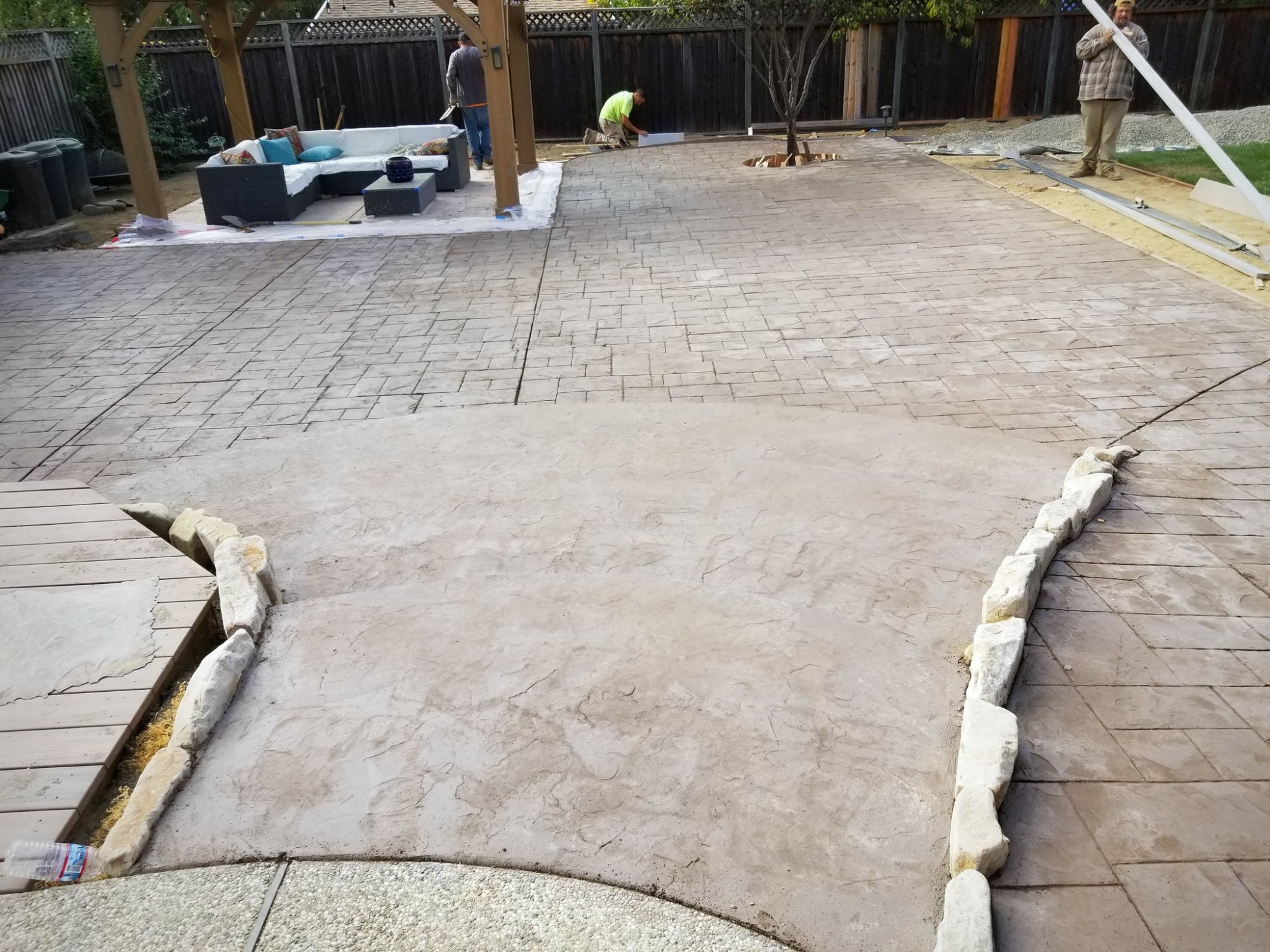 Stamped concrete patio with stone-edged borders in the same backyard