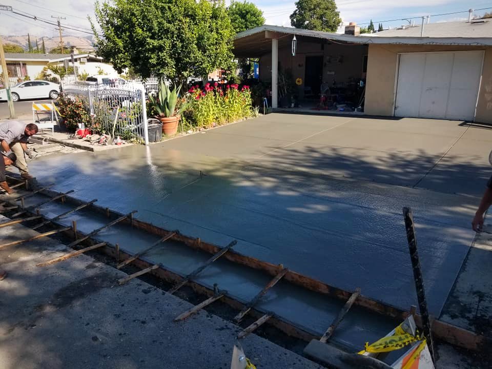 Crew finishing a freshly poured concrete driveway