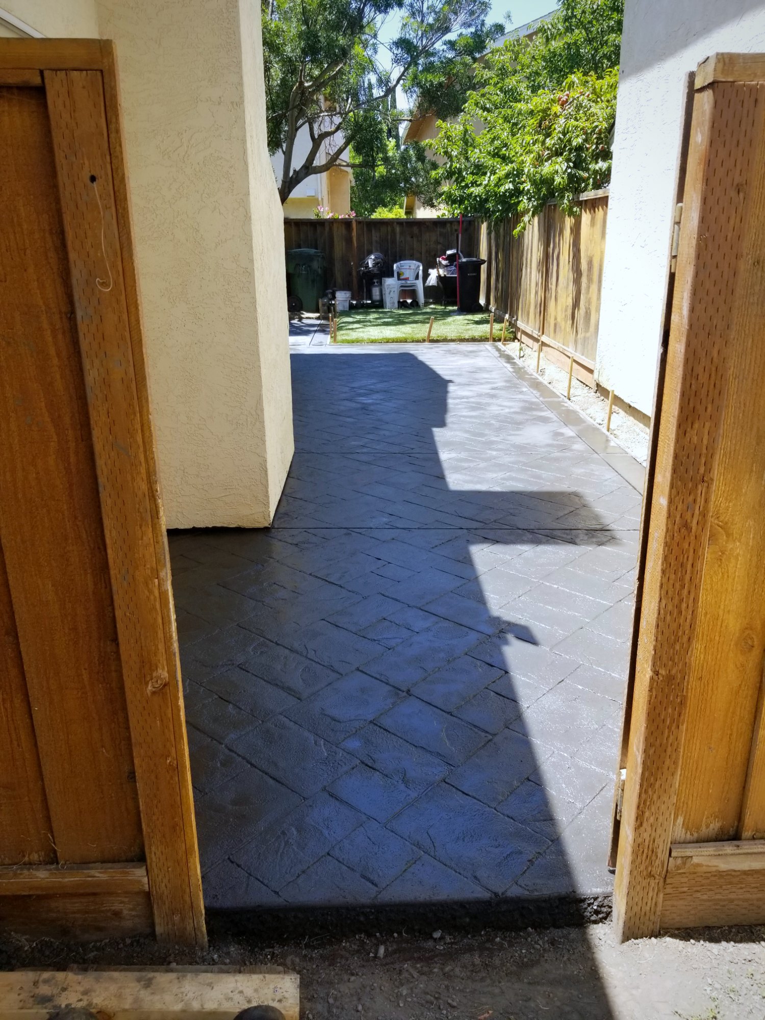 Charcoal stamped concrete walkway running between houses