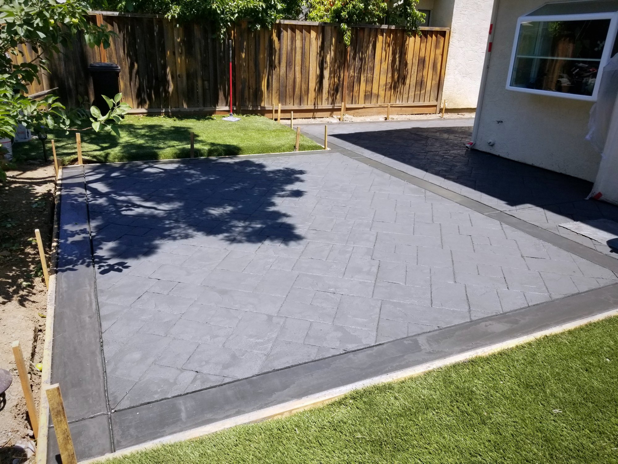 Two-tone ashlar stamped concrete patio with charcoal border