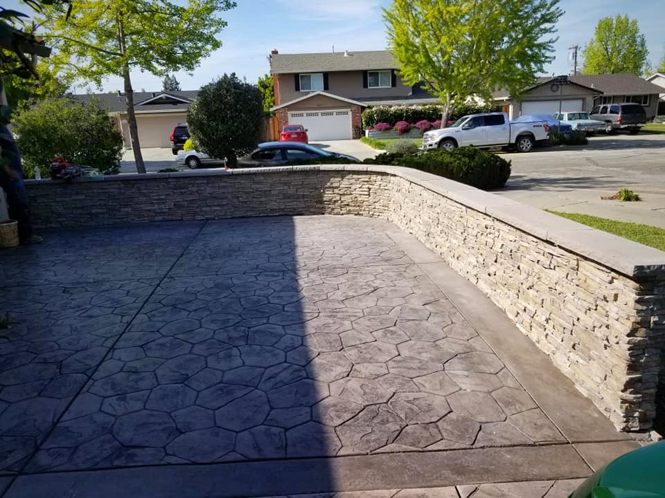 Stamped driveway with stacked stone retaining wall