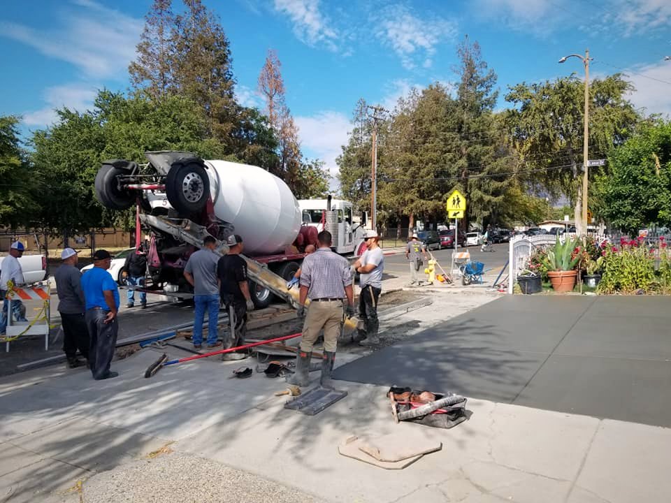 Crew and mixer truck pouring a commercial slab on a city street